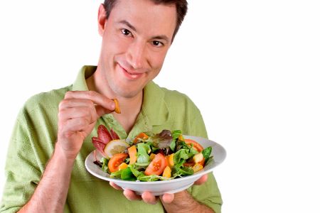 Мужчина держит в руках тарелку с овощами