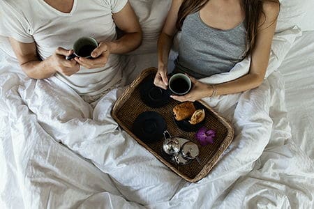 мужчина и женщина завтракают в постели