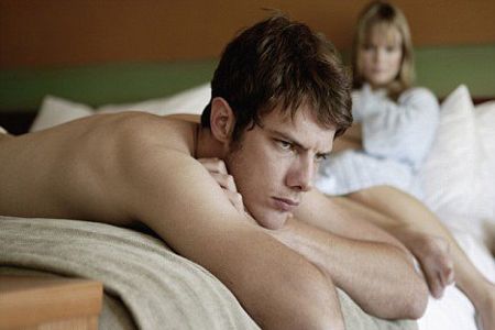 Мужчина лежит на животе в постели Мужчина лежит на животе в постели